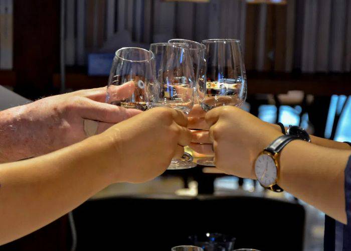 Four sake glasses being clinked at a Niigata sake tour, tasting and masterclass.